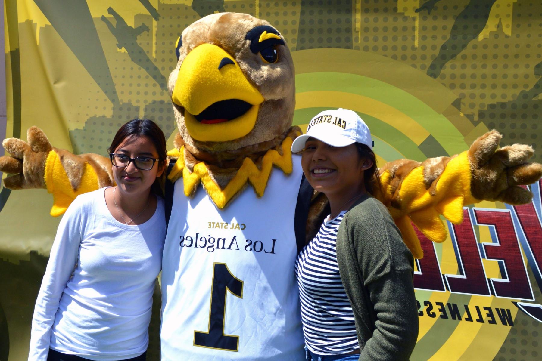 Eddie the Golden Eagle poses with two students.